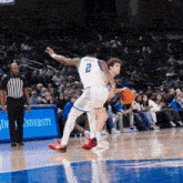a basketball game is being played in front of a sign that says university