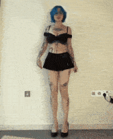a woman with blue hair and tattoos on her arms and legs