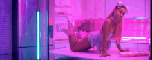 ariana grande is kneeling on a table in a pink room in a video .
