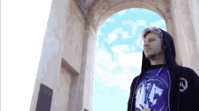 a man wearing a black hoodie and a purple shirt that says nf