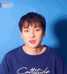 a man wearing a blue shirt that says cattitude on it