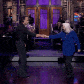 a man and a woman are dancing on a stage with a sign in the background that says ' abc '