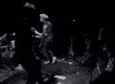 a black and white photo of a group of people playing instruments on a stage