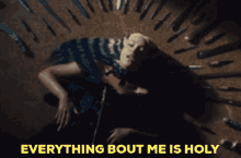 a woman is laying on the ground with the words " everything bout me is holy "
