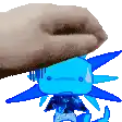 a hand is holding a blue axolotl toy .