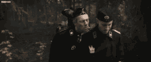 two men in military uniforms are walking in the woods with a watermark that says wpnevoid