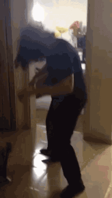 a man in a black shirt is standing on a tile floor