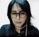a close up of a woman wearing glasses and earphones .