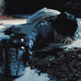 a person is laying on the floor with a bucket of liquid on the floor