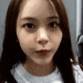 a close up of a woman 's face with a white t-shirt on