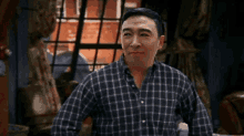 a man in a plaid shirt is smiling and looking at the camera