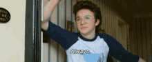 a young man wearing glasses and a pink floyd shirt says always .