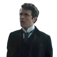 a man in a tuxedo and tie looks to the side