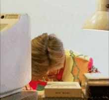 a woman is sitting at a desk with a box that says ' a ' on it