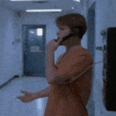 a man talking on a phone in a hallway