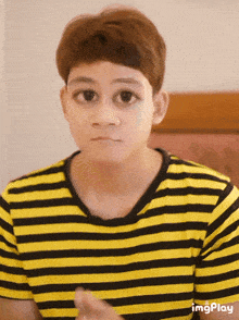 a person wearing a yellow and black striped shirt with imgplay at the bottom of the image