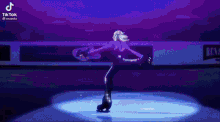 a person is ice skating on a rink in front of a purple light .