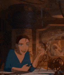 a woman in a blue shirt is sitting at a table with a fan in a dark room .
