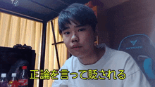 a young man sitting in front of a coca cola bottle and a gaming chair