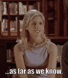 a woman is sitting in front of a bookshelf and saying " as far as we know "