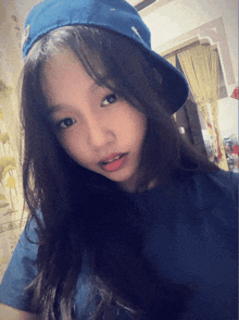 a young girl wearing a blue hat and a black shirt