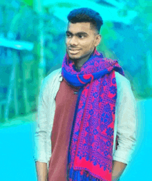 a young man wearing a red and blue scarf is smiling