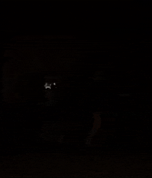 a person is standing in a dark room with a light coming out of the corner .