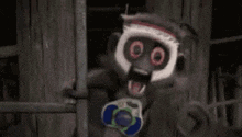 a scary monkey is holding a toy gun in a dark room .