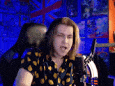 a man with long hair is singing into a microphone while wearing a shirt that says lemons on it