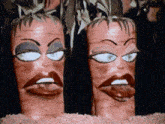 two carrots with female faces painted on them are standing next to each other