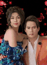 a man and a woman posing for a picture with red butterflies in the background