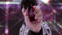 a person is holding a red object in their hand .