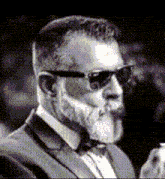 a man with a beard and sunglasses is wearing a tuxedo