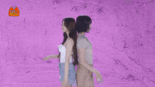 two women are standing next to each other with cats drawn on the wall behind them