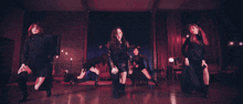 a woman is dancing in front of a group of people in a dark room .