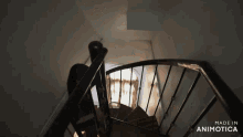 a person walking up a spiral staircase that is made in animatica