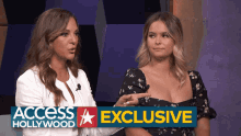 two women are sitting next to each other in front of a banner that says access hollywood