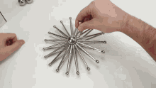 a person is playing with a starburst made of metal sticks
