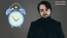 a man stands in front of an alarm clock with the name emile aleman on the bottom left