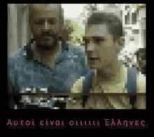 two men are standing next to each other in a blurry photo with the words autoi einai on the bottom right