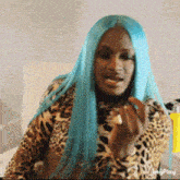 a woman with long blue hair is wearing a leopard print top