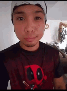 a man wearing a deadpool t-shirt takes a selfie