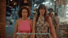 two women are walking down a street and one of them says man you girls are so pretty .