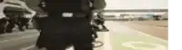 a blurry picture of a police officer standing on a green runway .