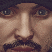 a close up of a man 's face with a beard and blue eyes