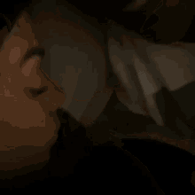 a woman with a nose ring is sleeping in a bed with a pillow .