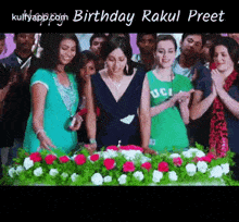 a group of people standing around a table with flowers and the words birthday raku preet at the top