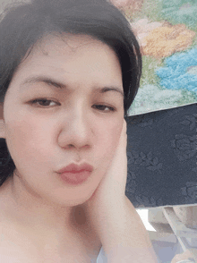 a woman 's face is shown with her hand on her chin