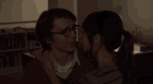 a man and a woman are kissing in the dark