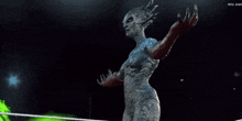 a woman with a body painted like a monster stands in front of a green sign that says arca juan